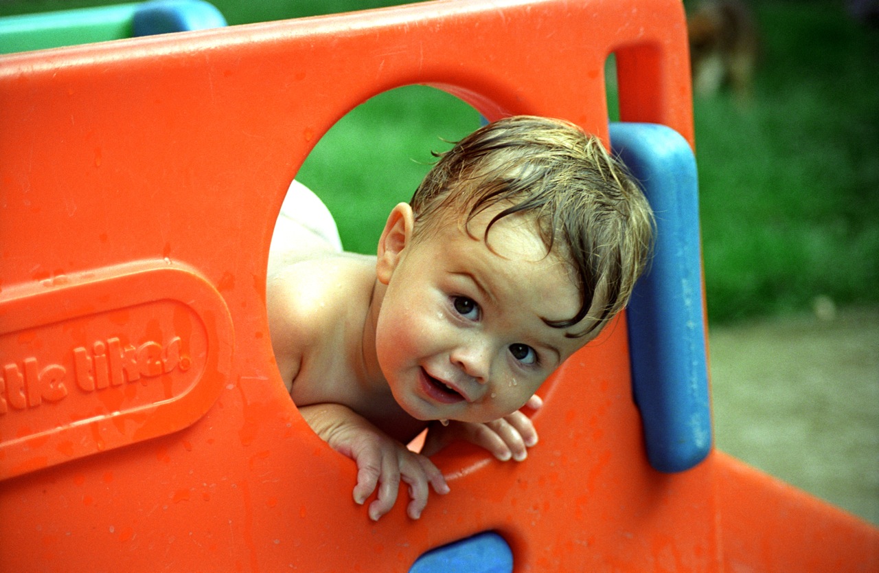 Young boy playing on a slide.